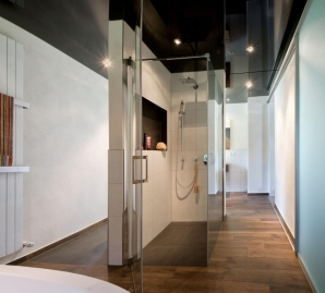 Das Badezimmer besticht dank einer spiegelnden Lackspanndecke durch zeitlose Eleganz.