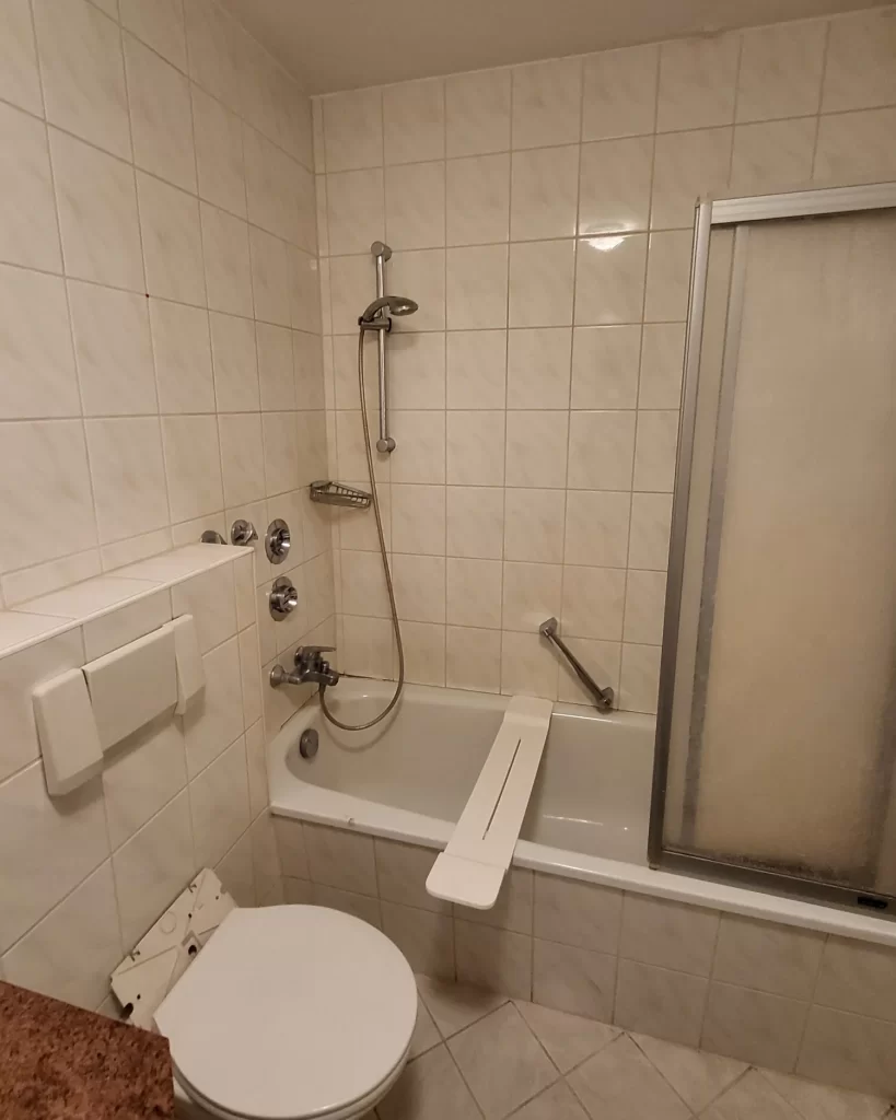 Bestandsbad mit Badewanne und Duschtrennwand