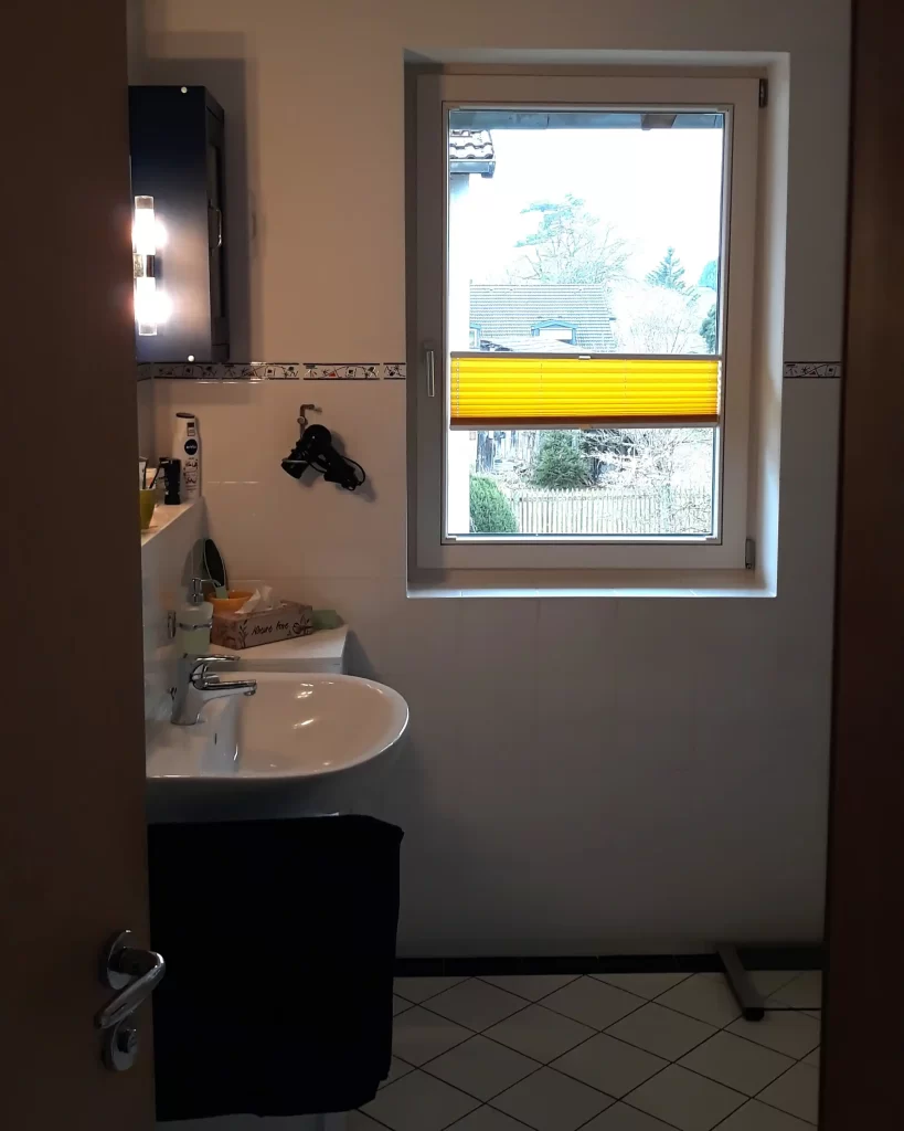 Bestandsbadezimmer mit Waschbereich und Fenster