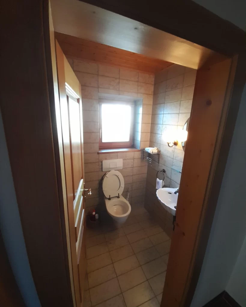 Vorher- Rustikales Gäste-WC mit Holzdecke und Fliesenwänden