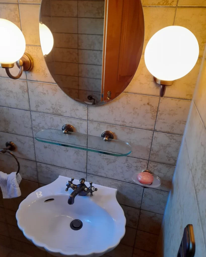 Vorher-Waschbereich mit Muschelbecken und Wandlampen