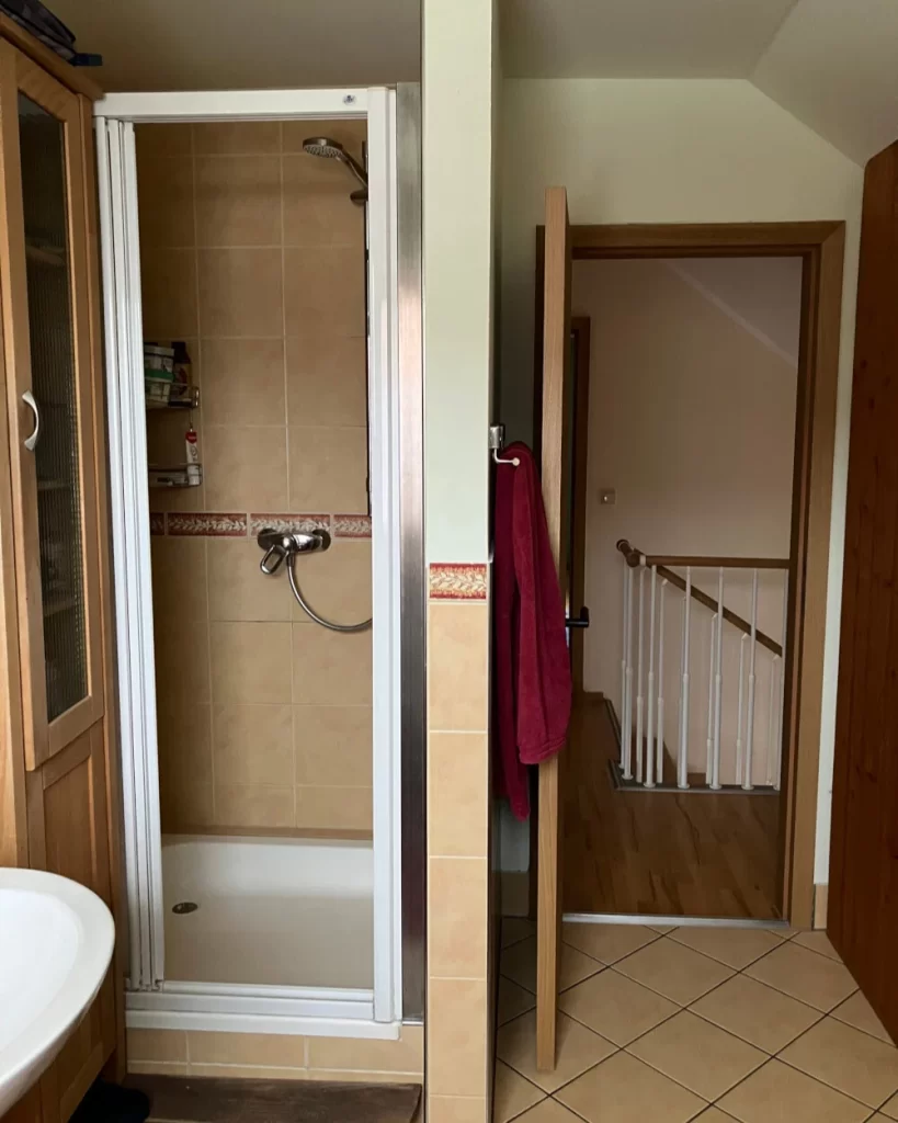 Vorher- Enge Duschkabine und altmodische Fliesengestaltung