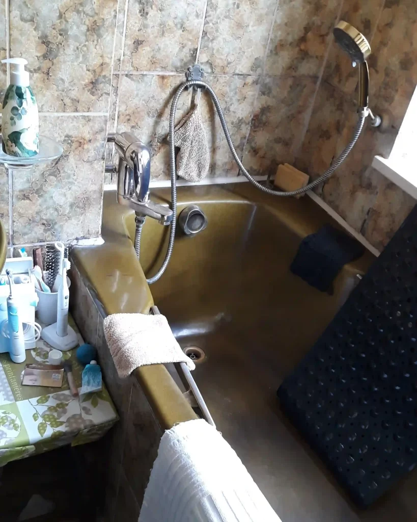 Bestandsbad mit eingelassener Wanne und Armaturen im 70er-Jahre-Stil